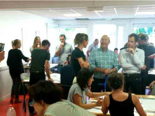 Représentation photographique de personnes réunies dans un salle d'une école assujettie au décret tertiaire
